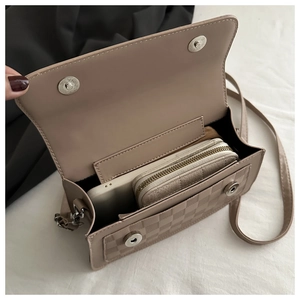 Detail view of khaki crossbody bag interior with dual magnetic snaps and storage space