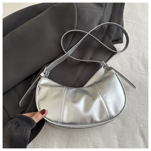 Détail du sac hobo argenté avec finition métallique et bandoulière réglable sur tissu
