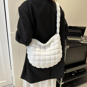 White quilted puffer crossbody bag featuring a minimalist lattice pattern and wide strap