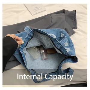 Grande borsa tote in denim blu con dettagli distressed e ampio spazio interno per oggetti