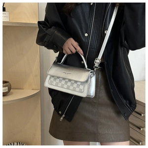 Close-up of silver mini crossbody bag with checkered pattern and adjustable shoulder strap
