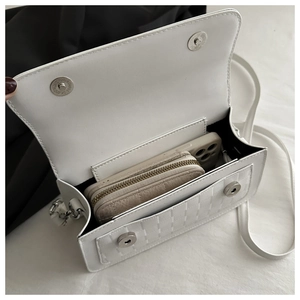 Detail of white woven crossbody bag interior showing spacious room for wallet and phone