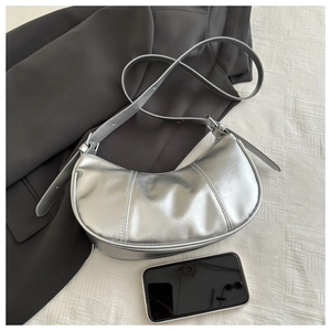 Detail of silver crescent hobo bag with adjustable strap and textured stitching finish