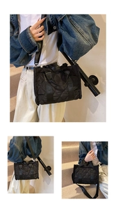 Detail view of black quilted nylon tote bag with adjustable strap for versatile styling