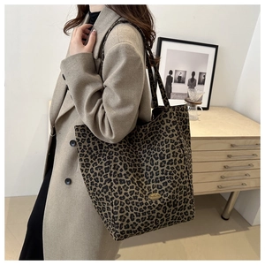 Détail du sac cabas léopard avec plaque logo en métal et bandoulières en nylon