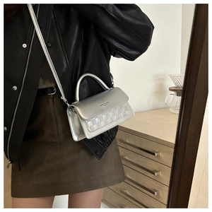 Silver mirror crossbody bag with white checkerboard woven texture shown on a model