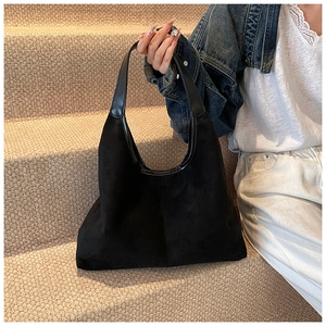 Detail of minimalist black matte hobo bag with contrast glossy trim and sleek vertical stitching
