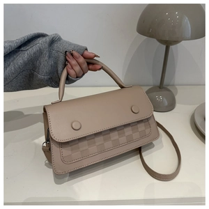 Detail of beige faux leather handbag with checkered pattern and decorative buttons