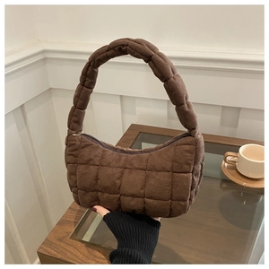 Close-up of brown quilted hobo bag with grid patterns and metal zipper detail
