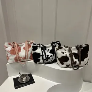 Détail de sacs cabas en peluche avec motifs vache en rose, noir et marron en fausse fourrure