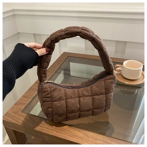 Close-up of brown quilted shoulder bag showing suede-like texture and puffy stitching