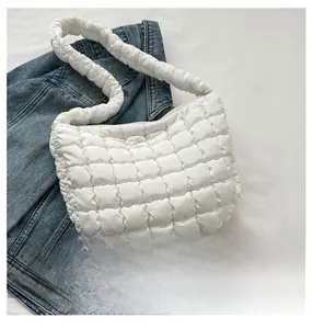 Detail showing the white quilted texture and puffy handle of this cloud shoulder bag