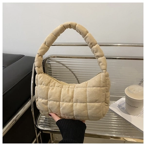 Close-up of beige quilted checkered handbag featuring a ruched handle design on display