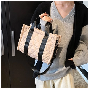 Vista dettagliata della borsa trapuntata beige con cinturini a contrasto neri e ganci