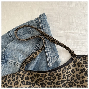 Gros plan du sac cabas en nylon à motif léopard avec une veste en jean
