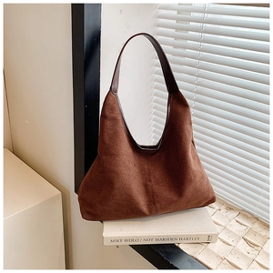 Close-up of deep brown suede hobo bag with vintage texture on a window sill