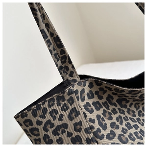 Détail du nylon imprimé léopard avec coutures précises sur la poignée du sac à bandoulière