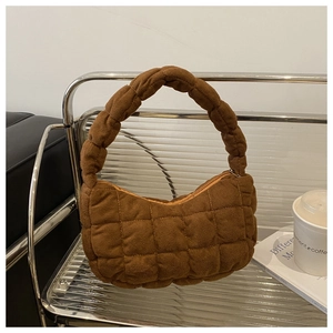 Close-up of quilted brown faux suede shoulder bag with puff texture and top zipper