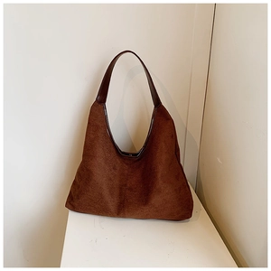 Close-up of deep brown suede hobo tote bag with smooth coffee leather strap handle