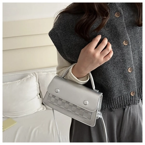 Silver faux leather crossbody bag with checkered pattern detail shown in a lifestyle setting