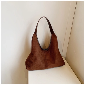 Macro detail of dark brown suede hobo tote bag featuring central seam reinforcement