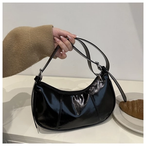 Glossy black patent leather crescent shoulder bag with adjustable strap and stitching