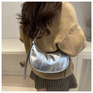 Detailed view of silver crescent hobo bag with vertical stitching on smooth PU leather