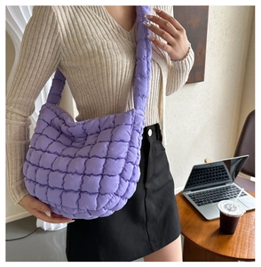 Detail of purple puffer tote bag with quilted bubble texture shown on shoulder