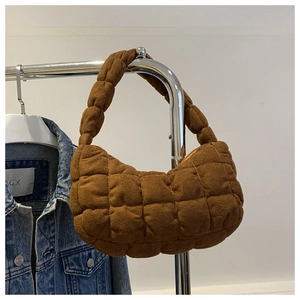 Close-up of brown quilted shoulder bag with bubble texture and soft suede-like finish