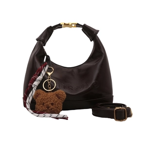 Fashionable dark coffee croissant shoulder bag with glossy patent leather and teddy bear charm