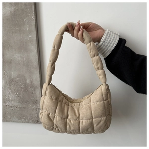 Close-up of quilted puffer shoulder bag with square stitching and integrated handle
