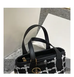 Détail du sac cabas en tweed bicolore avec poignées mates et fermetures éclair dorées
