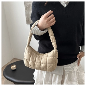 Détail du sac à main matelassé beige avec surpiqûres quadrillées et texture nuage douce
