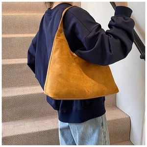 Detailweergave van een grote vintage gele suède hobo schoudertas in een casual setting