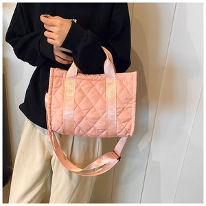 Detail of pink quilted tote bag with diamond stitching and adjustable shoulder strap