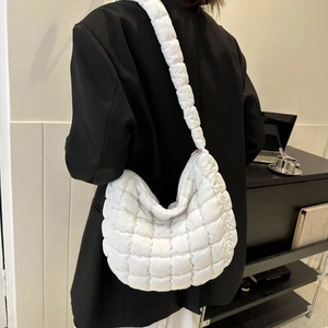 Detail of white quilted puffy shoulder bag styled with a professional black blazer