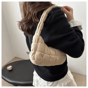 Vue latérale du sac hobo matelassé beige au toucher daim porté à l'épaule sur mannequin
