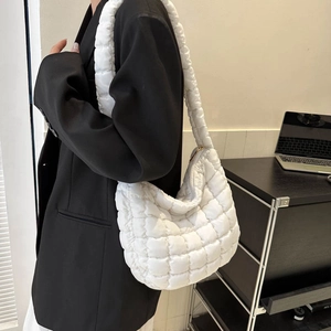 Detail of white quilted puffy shoulder bag with premium padded texture and grid pattern