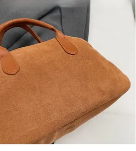Detail shot of brown frosted suede texture and precision stitching on the handle