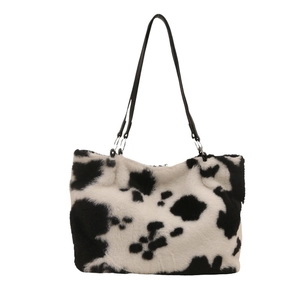 Furry tote bag with black and white cow print texture and slim black shoulder straps