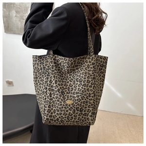 Détail du sac cabas à imprimé léopard élégant avec une plaque de logo en métal faite main