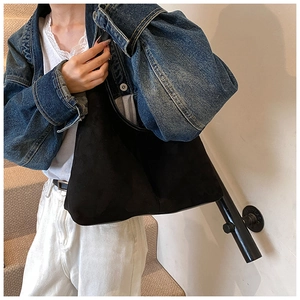 Detail of minimalist black matte hobo bag showing its soft texture and slouchy shape