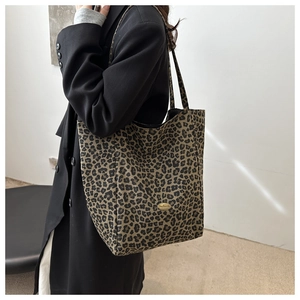 Détail du sac cabas à imprimé léopard avec logo métallique et texture en toile épaisse