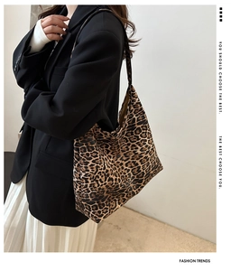 Detailed side profile of a large leopard print canvas tote bag on female model's shoulder