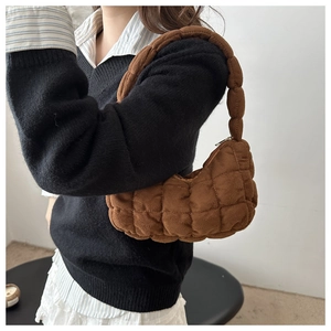 Détail de sac à main matelassé marron avec texture plissée en velours côtelé