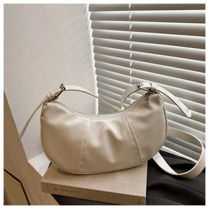 Detail of off-white pleated hobo bag with adjustable strap and silver zipper hardware