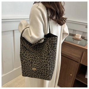 Sac fourre-tout léopard en nylon avec plaque 'Handmade' porté à l'épaule par un mannequin