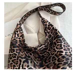 Detail of vintage leopard print tote bag showing wide handle and leather texture