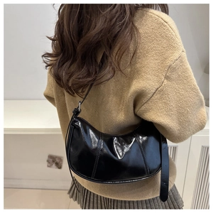 Sac croissant noir brillant avec coutures verticales et détails de sangle réglable
