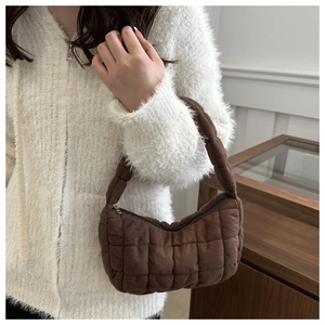 Détail du sac à main matelassé marron foncé avec texture douce et fermeture éclair dorée